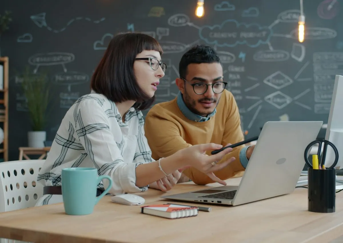 Two colleagues collaborating on a laptop